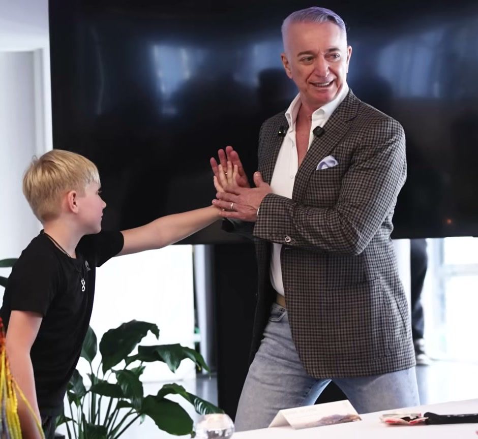 Meir Ezra teaching a live class, sharing a high five with a young student